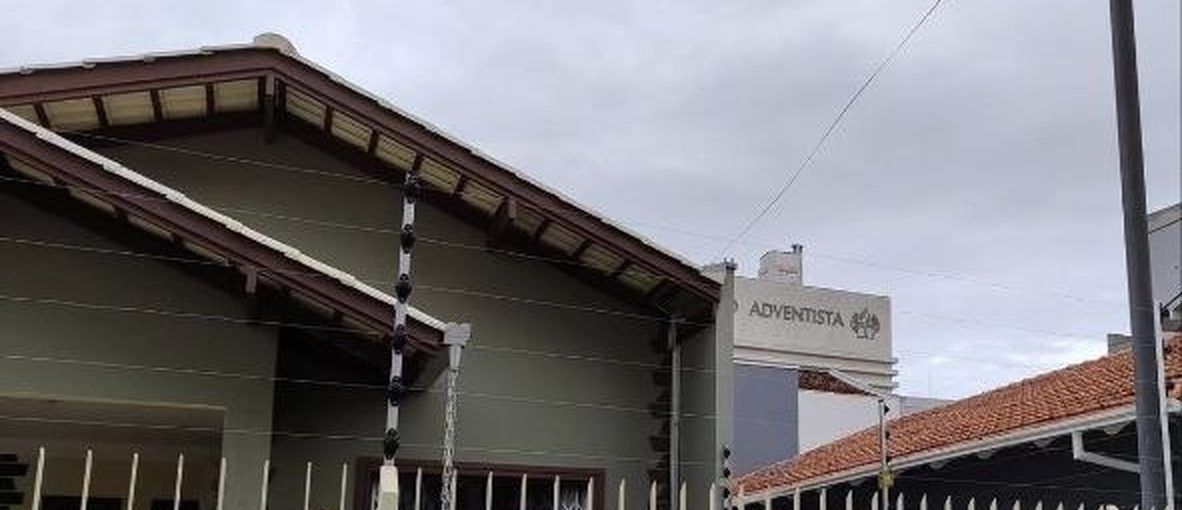 Casa com cerca elétrica correndo pelo alto da fachada e do muro lateral